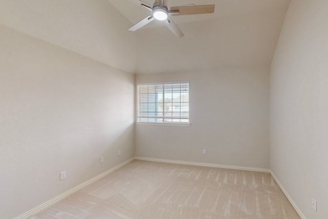 spare room featuring light colored carpet, baseboards, and a ceiling fan