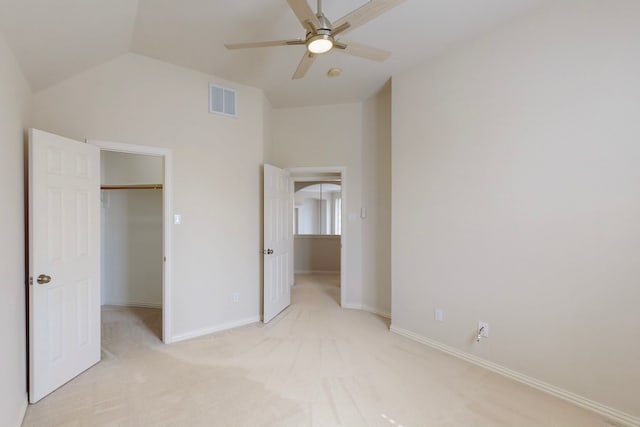 unfurnished bedroom with a spacious closet, visible vents, baseboards, light colored carpet, and lofted ceiling