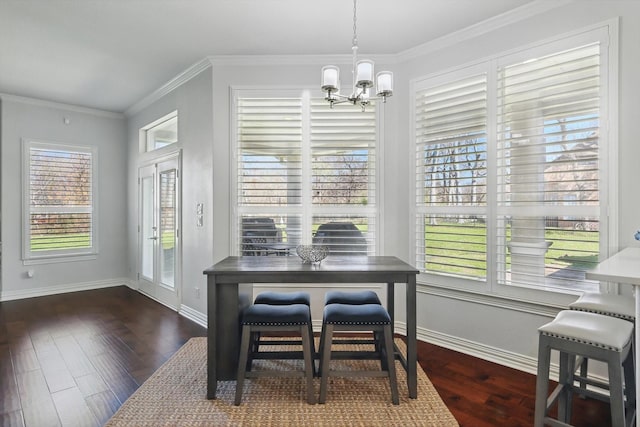 dining space with baseboards, wood finished floors, a chandelier, and ornamental molding