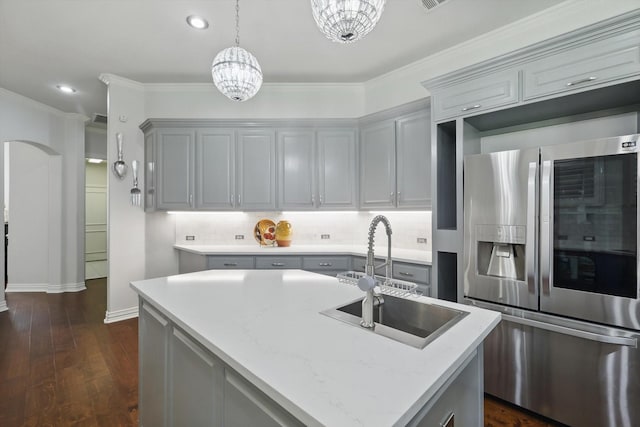 kitchen featuring dark wood finished floors, stainless steel fridge with ice dispenser, gray cabinets, a sink, and hanging light fixtures