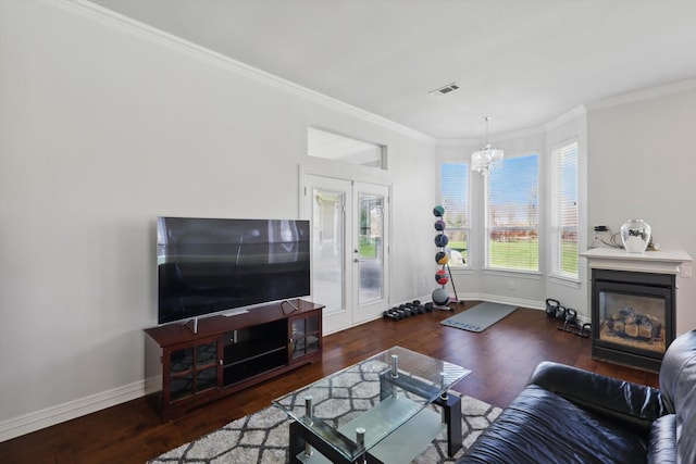 living area featuring a glass covered fireplace, visible vents, baseboards, and wood finished floors