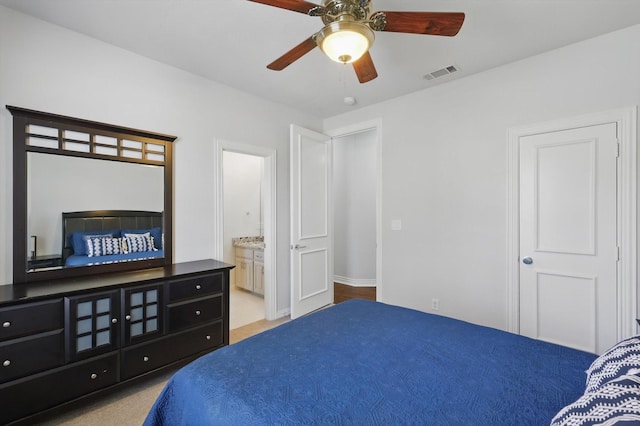 carpeted bedroom with ensuite bath and visible vents