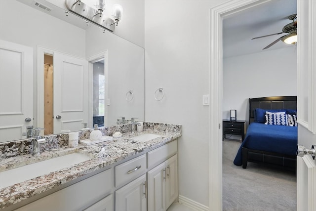 ensuite bathroom with a sink, visible vents, double vanity, and a ceiling fan