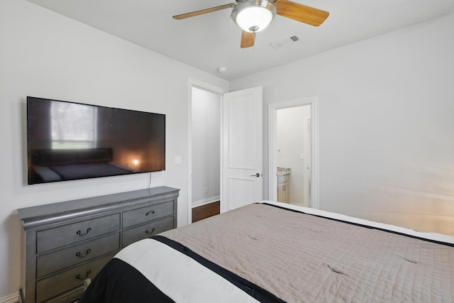 bedroom featuring ensuite bath, baseboards, visible vents, and ceiling fan