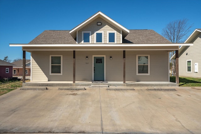 bungalow-style home with covered porch and roof with shingles