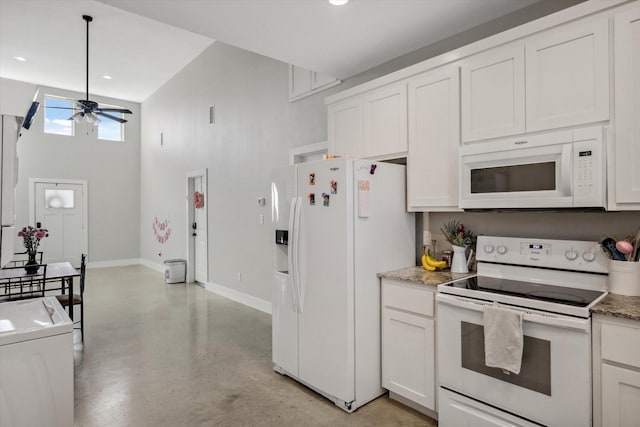 kitchen with white appliances, a ceiling fan, concrete floors, washer / dryer, and white cabinets