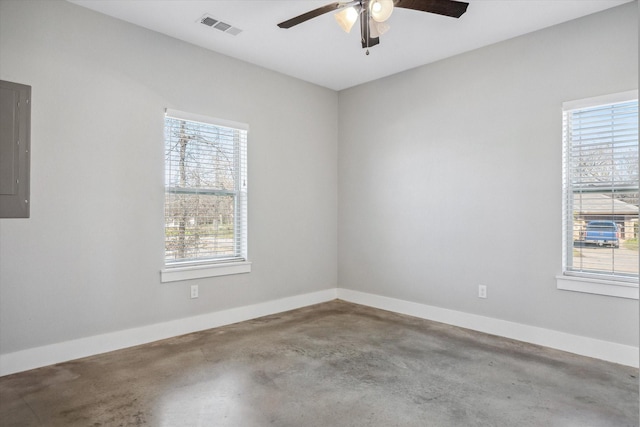 unfurnished room with visible vents, electric panel, baseboards, concrete flooring, and ceiling fan