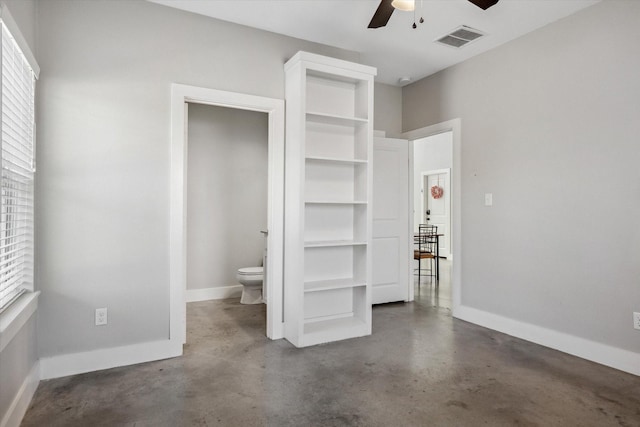 unfurnished bedroom featuring visible vents, baseboards, concrete flooring, and ceiling fan