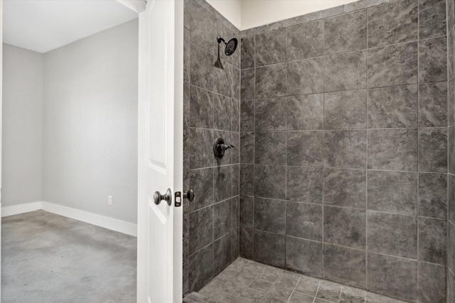 bathroom with baseboards and a tile shower