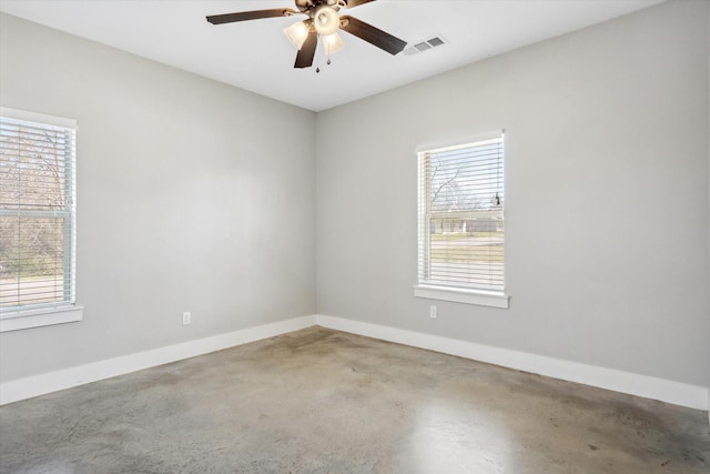 unfurnished room featuring a wealth of natural light, visible vents, and ceiling fan