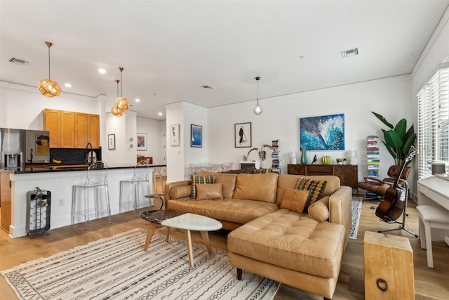 living room featuring recessed lighting, visible vents, and light wood finished floors