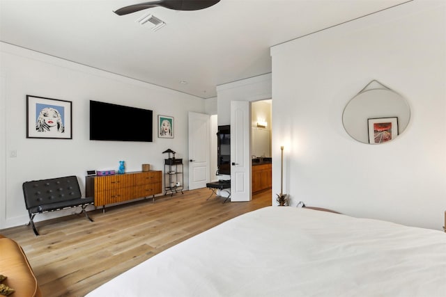 bedroom featuring visible vents, ensuite bathroom, and light wood finished floors