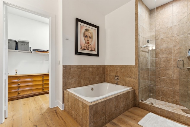 full bath with a shower stall, a garden tub, and wood finished floors