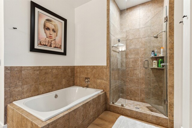 bathroom with a shower stall and a garden tub