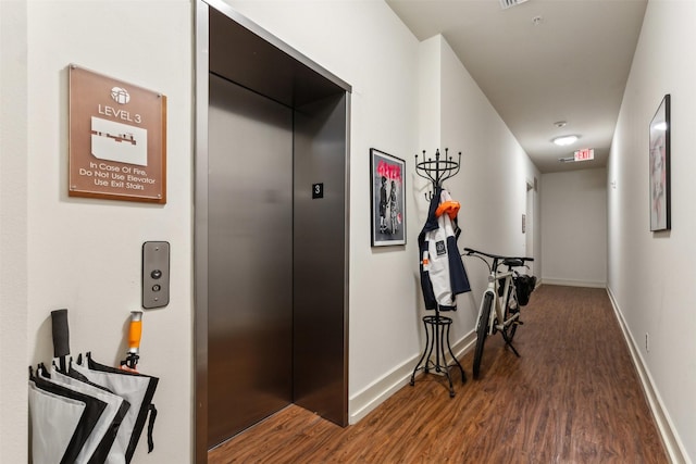 hall with elevator, wood finished floors, and baseboards