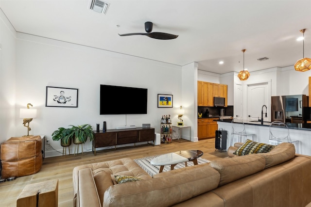 living area featuring light wood-style flooring, recessed lighting, visible vents, and ceiling fan