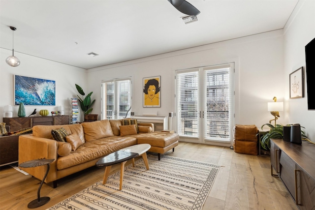 living room with visible vents and light wood-style flooring