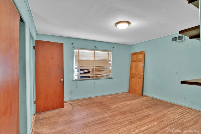 unfurnished room with visible vents and wood-type flooring