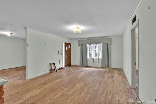 interior space with wood finished floors and crown molding