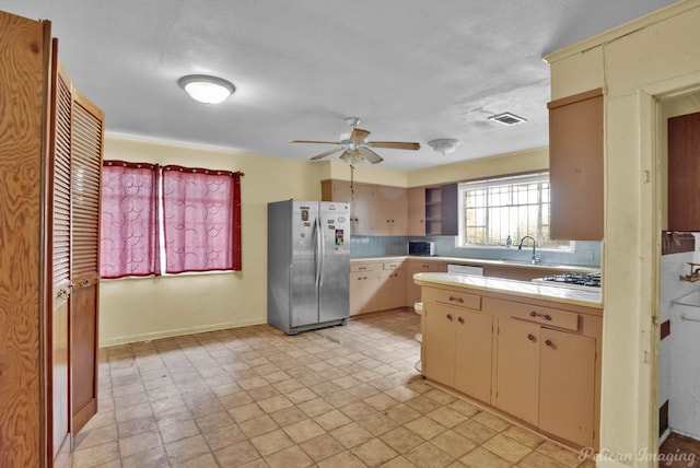 kitchen with tasteful backsplash, visible vents, light countertops, freestanding refrigerator, and cream cabinetry