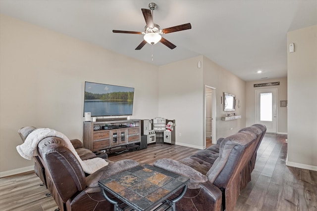 living room featuring a ceiling fan, baseboards, and wood finished floors