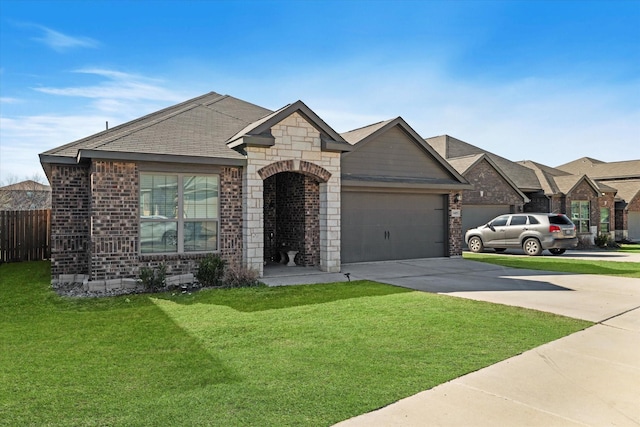 french country style house featuring brick siding, an attached garage, a front lawn, fence, and driveway