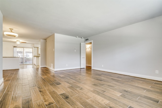 unfurnished living room with visible vents, baseboards, ceiling fan, and wood tiled floor