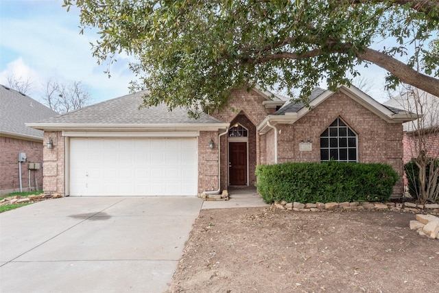 ranch-style house featuring a garage, brick siding, roof with shingles, and driveway