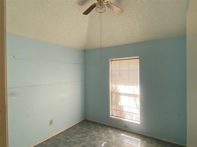 unfurnished room with vaulted ceiling, a ceiling fan, tile patterned floors, and a textured ceiling