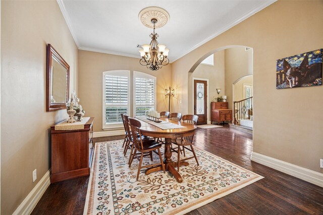 dining space featuring dark wood finished floors, an inviting chandelier, baseboards, and ornamental molding