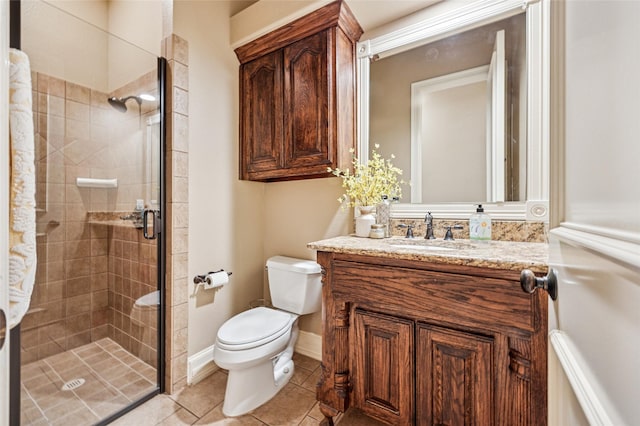 bathroom featuring tile patterned flooring, baseboards, toilet, a stall shower, and vanity