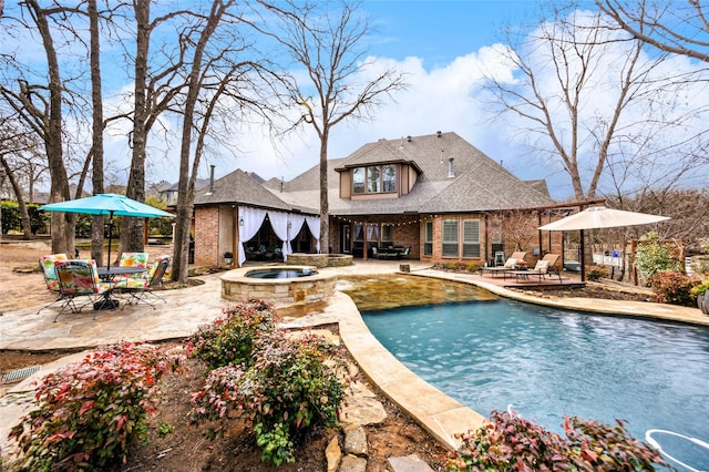 view of swimming pool featuring a jacuzzi, a swimming pool, and a patio area