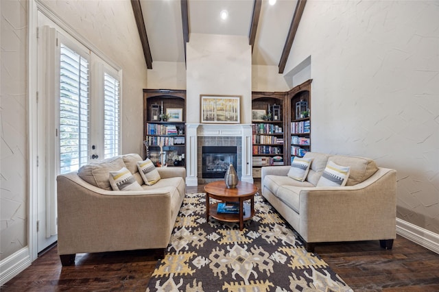 living area with a tile fireplace, vaulted ceiling with beams, a textured wall, and wood finished floors