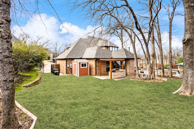 back of house featuring a yard, a patio area, brick siding, and roof with shingles