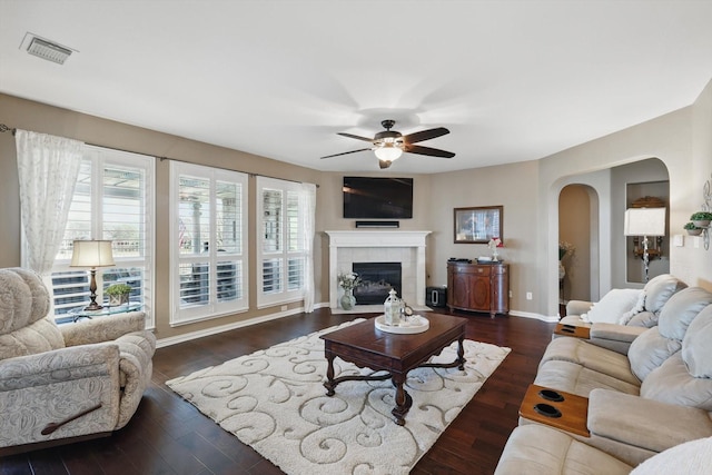 living room with dark wood finished floors, a healthy amount of sunlight, and visible vents