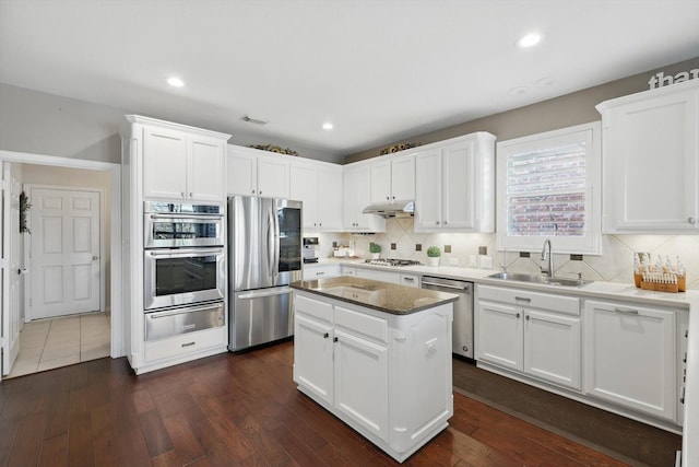 kitchen featuring a sink, appliances with stainless steel finishes, white cabinets, and dark wood-style flooring