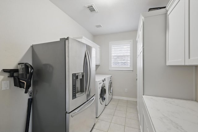 laundry area with light tile patterned floors, visible vents, baseboards, and washing machine and dryer