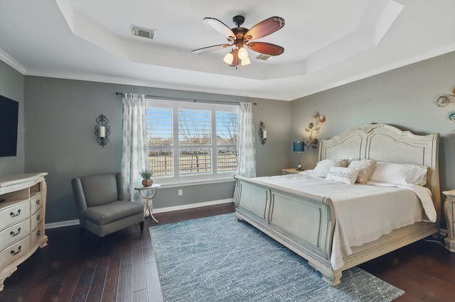 bedroom featuring baseboards, a raised ceiling, and dark wood-style flooring