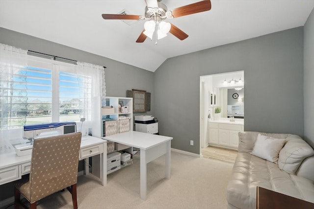 home office with baseboards, light colored carpet, ceiling fan, and vaulted ceiling