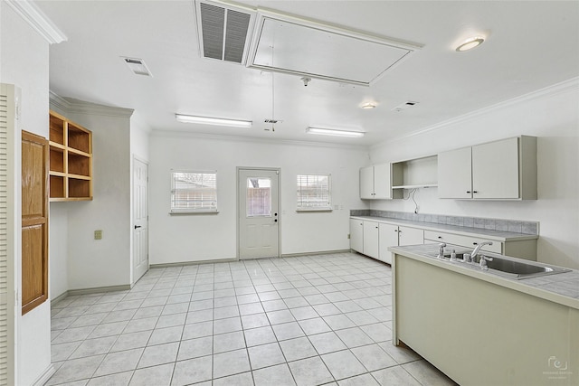 kitchen featuring visible vents, open shelves, ornamental molding, light tile patterned floors, and a sink