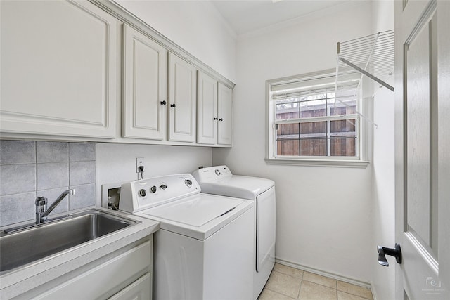 laundry room with ornamental molding, light tile patterned floors, cabinet space, independent washer and dryer, and a sink