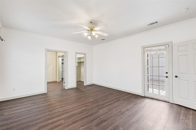 unfurnished bedroom with visible vents, baseboards, dark wood-type flooring, and crown molding