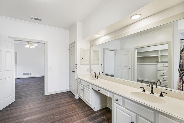 bathroom with double vanity, wood finished floors, visible vents, and a sink