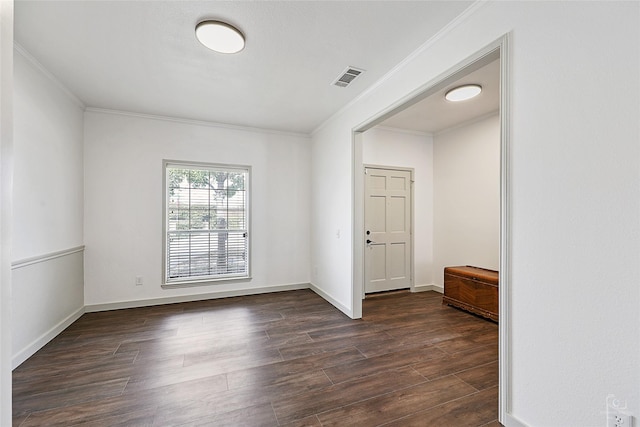 spare room featuring visible vents, crown molding, dark wood-type flooring, and baseboards