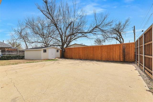 view of yard with an outbuilding, a fenced backyard, and a patio area