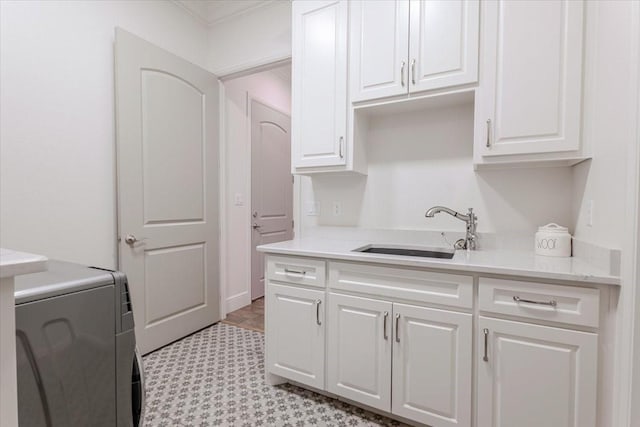 clothes washing area with cabinet space, washer / clothes dryer, and a sink