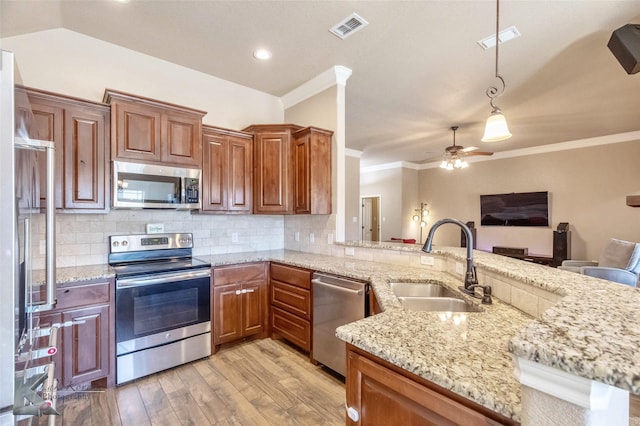 kitchen featuring visible vents, a sink, decorative backsplash, appliances with stainless steel finishes, and light wood-type flooring