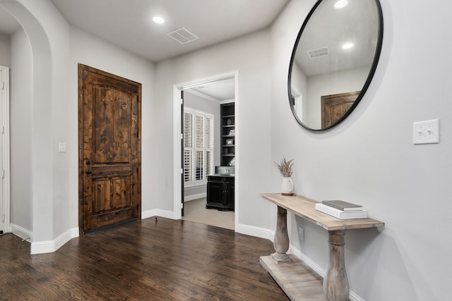 foyer entrance with visible vents, baseboards, and wood finished floors