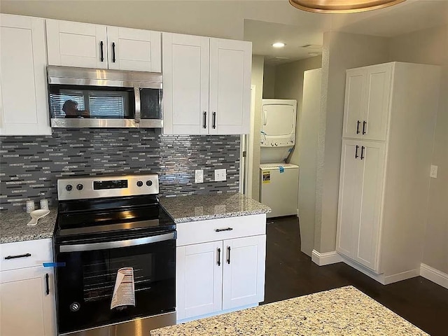 kitchen featuring stacked washer and dryer, white cabinetry, stainless steel appliances, decorative backsplash, and light stone countertops