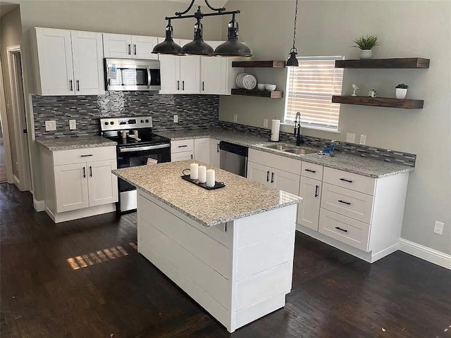 kitchen with open shelves, tasteful backsplash, appliances with stainless steel finishes, and a sink